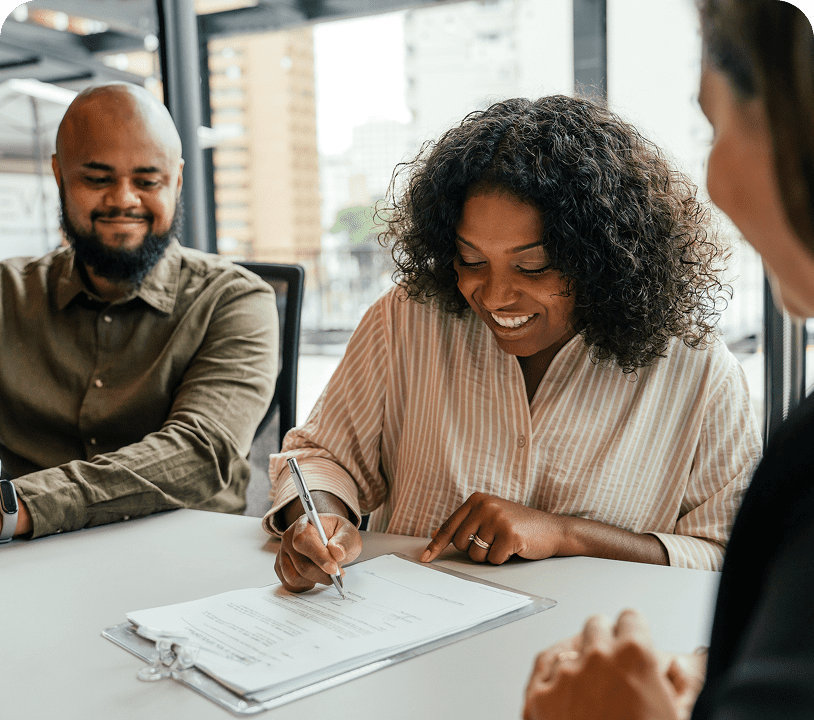 People signing documents at a meeting